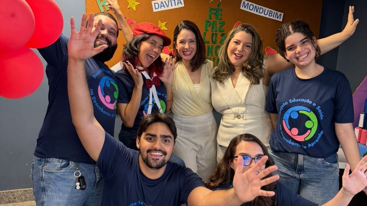 Ação no Mondubim: Equipe do projeto Educação e Saúde durante atividade na clínica DaVita. Na foto, os alunos vestem azul, acompanhados pela chefe da Divisão de Responsabilidade Social, Maely Borges (de amarelo), e pela coordenadora da ação, Renata Carneiro (de branco). Foto: Divulgação