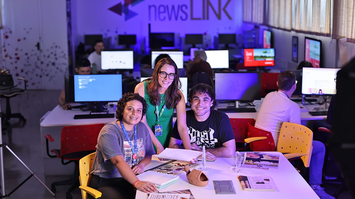 Vários estudantes utilizam computadores de um laboratório.