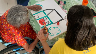 Voluntários conduzindo dinâmica de pintura na Casa de Nazaré (Foto: Divulgação)