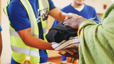 Doação de roupas a uma pessoa em situação de rua (Foto: Getty Images)