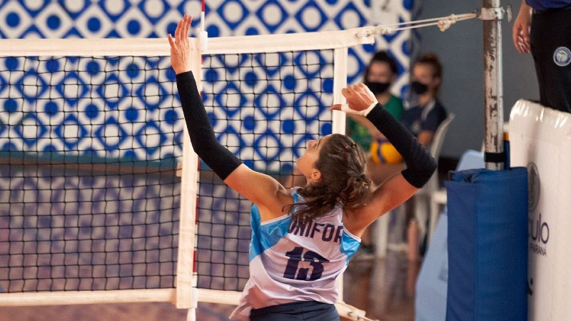 Atleta de vôlei salta para rebater a bola