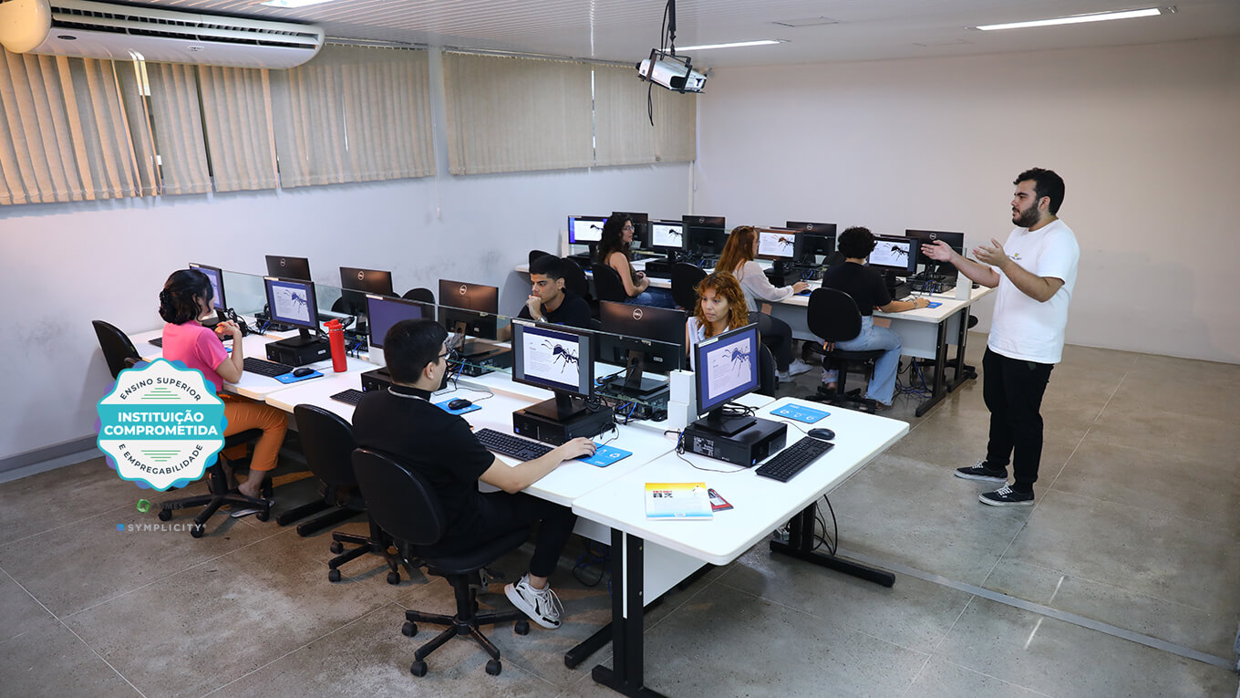 Estudante utilizando notebook em sala com paredes amarelas