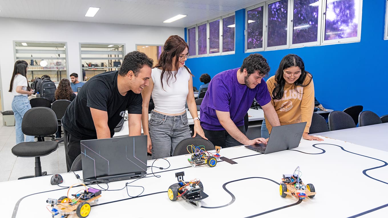 Jovens manipulam notebooks e projetos