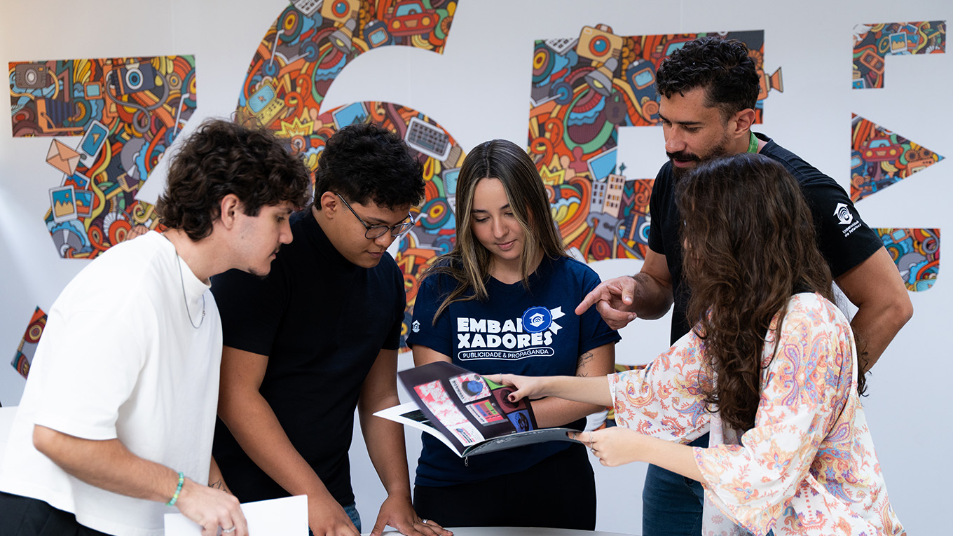 Estudantes sorriem. Ao fundo, há o logotipo da agência 365 Lab