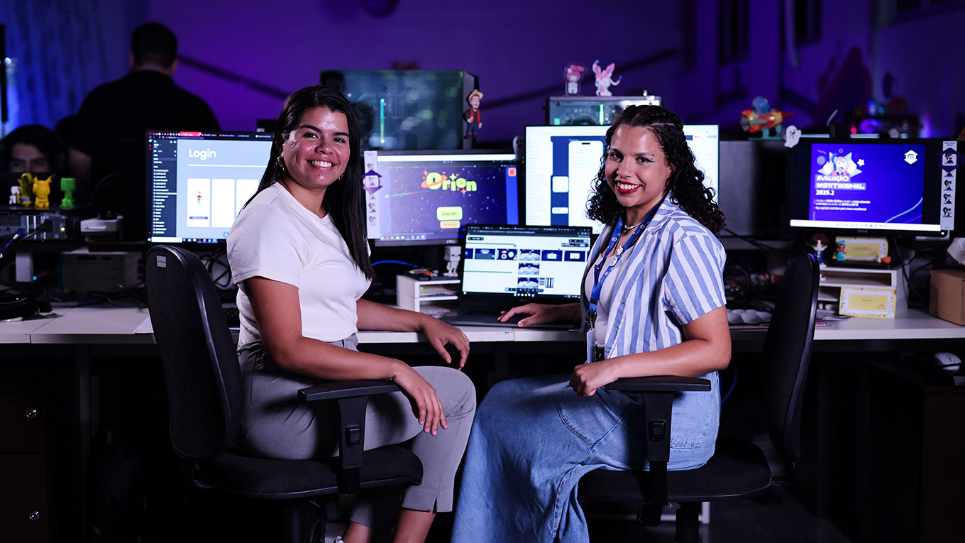 Duas jovens em frente a computadores