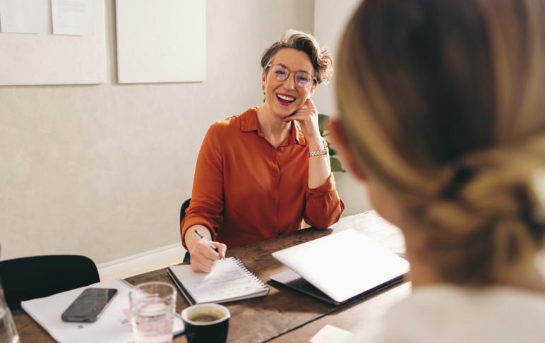 Empresária feliz entrevistando um candidato a emprego em seu escritório