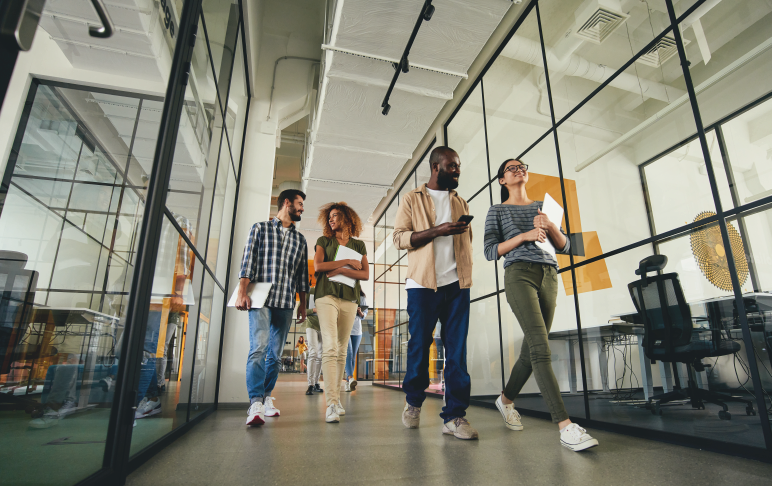 Jovens caminhando pela empresa em direção a salas