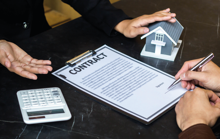 Um homem está assinando um contrato de aluguel imobiliário.