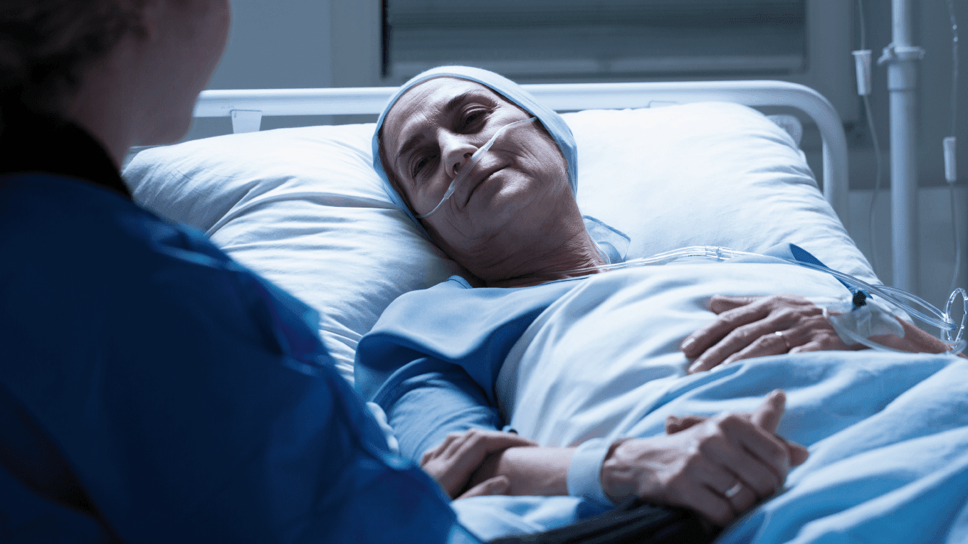 Uma mulher na cama de hospital segurando o braço de um médico