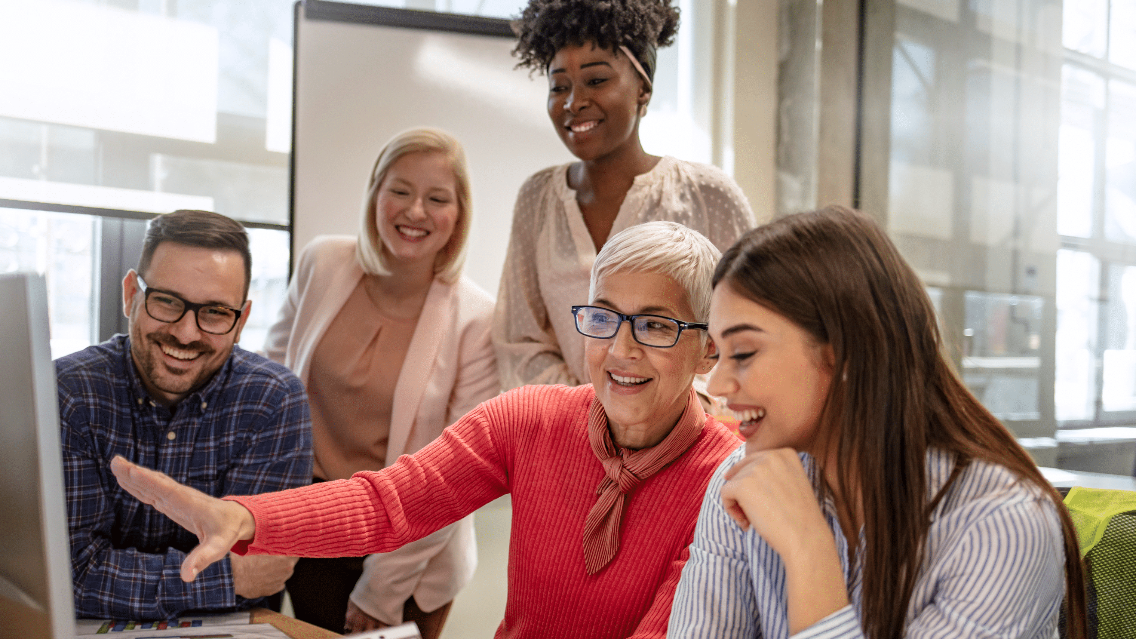 Pessoas diversas olhando para o computador discutindo estratégias de negócios