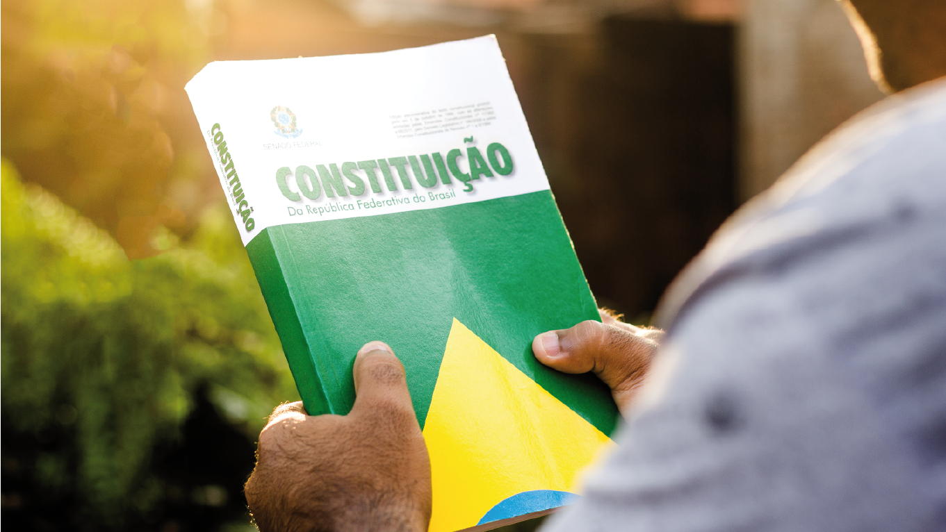 Profissional segurando a constituição brasileira