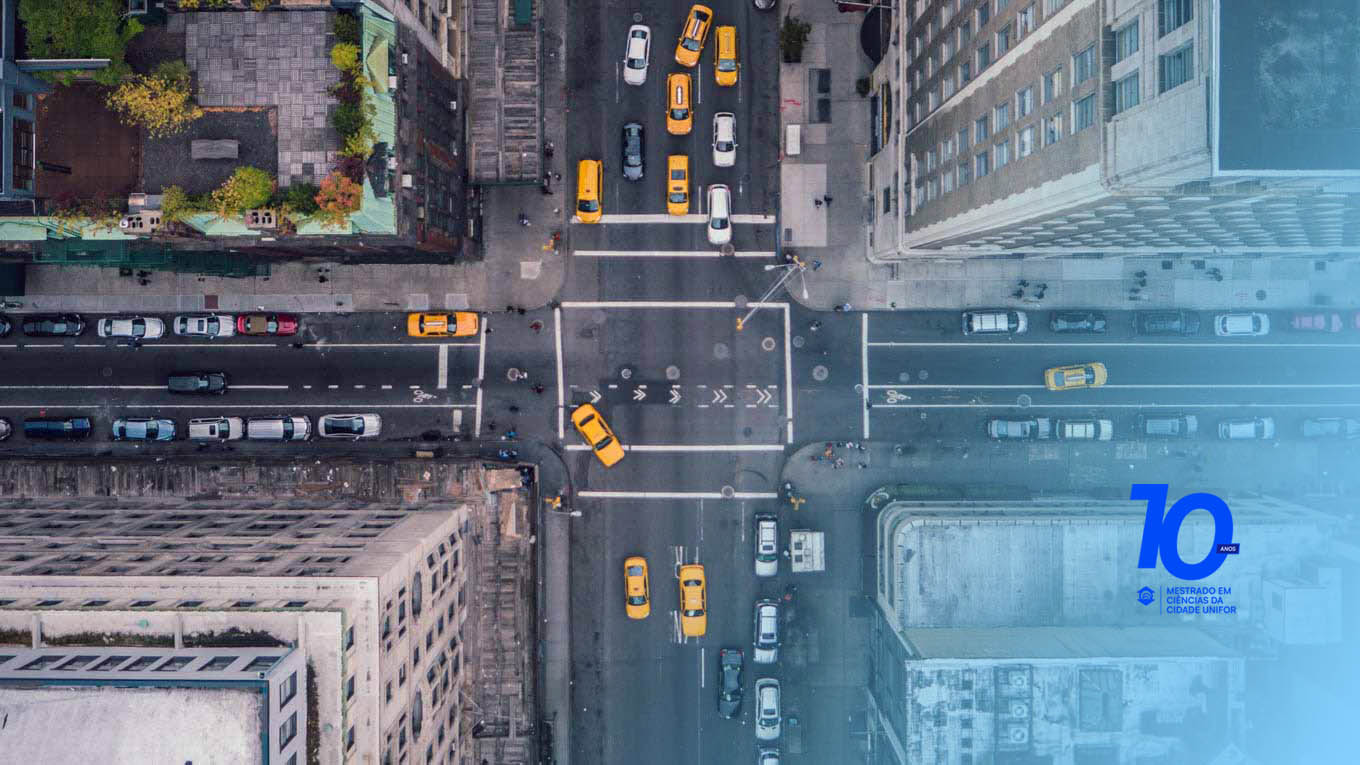 Os prédios, ruas e carros de uma cidade são vistos do alto.