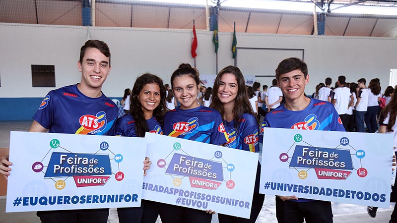 alunos do colégio Antares segurando cartazes informando que estarão na Feira de Profissões